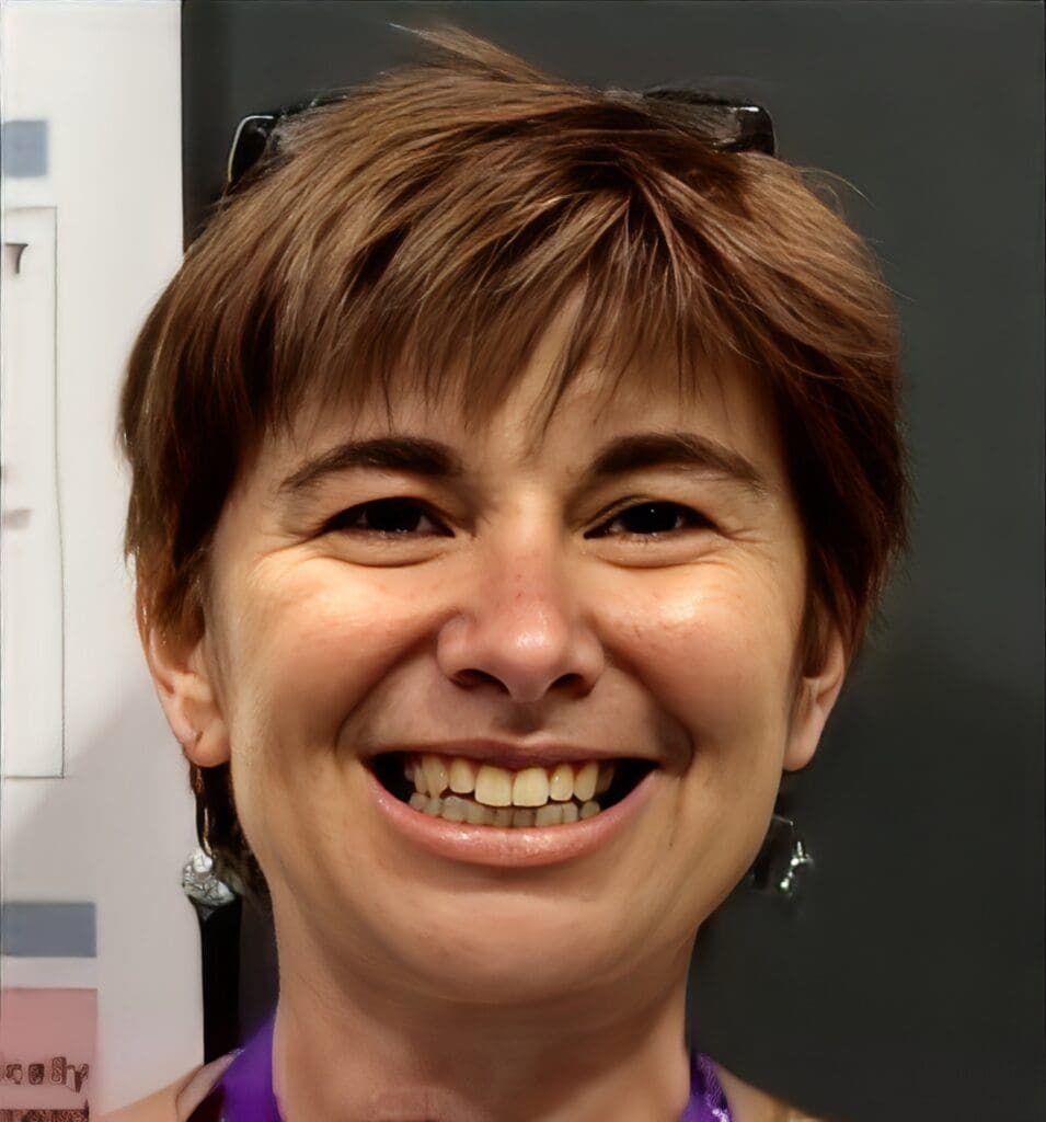 Smiling person with short brown hair.