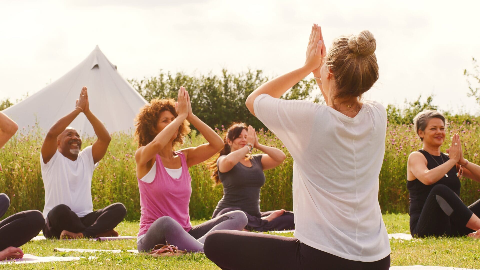 a group practicing yoga in a field
