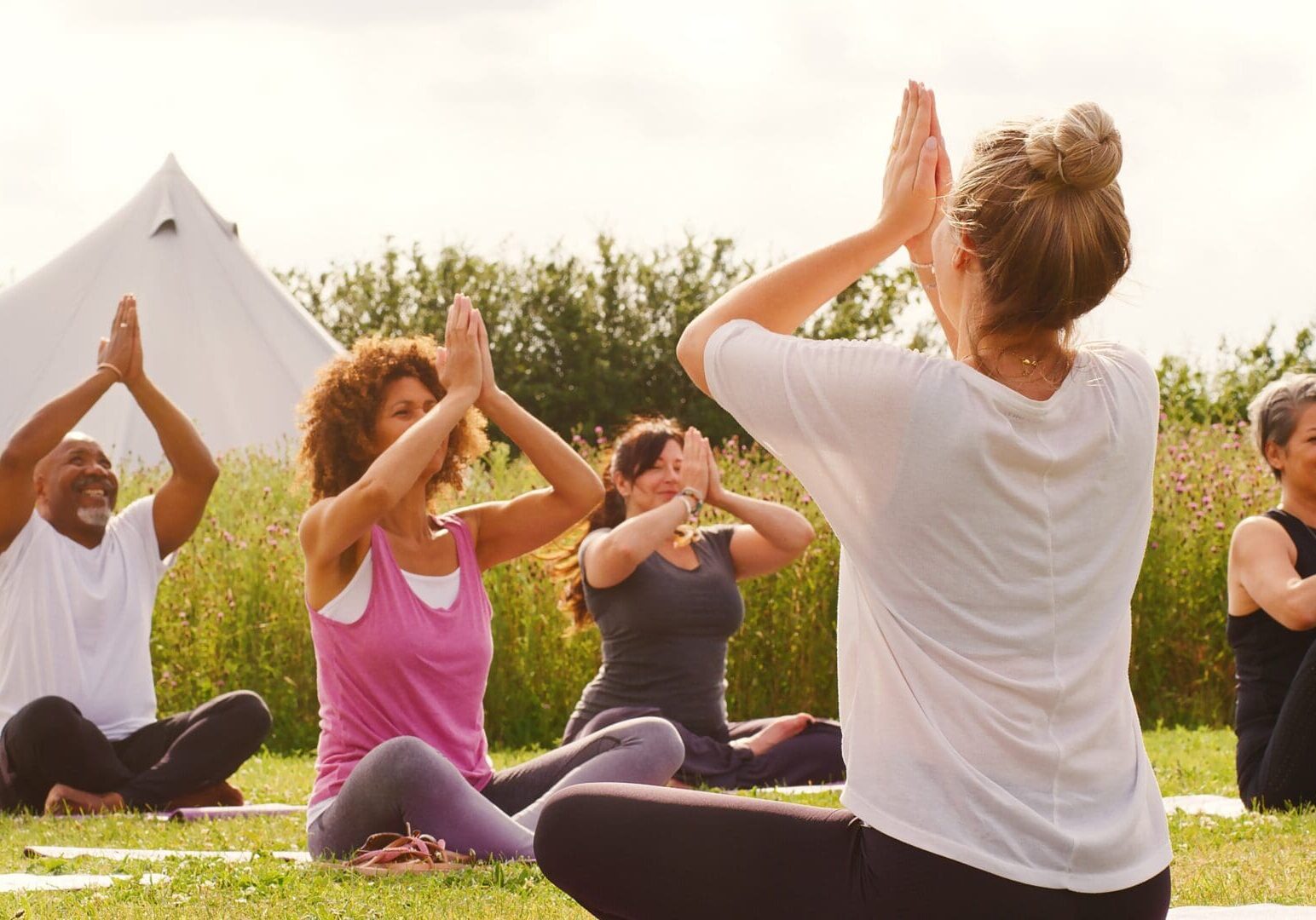 a group practicing yoga in a field